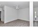 Bright bedroom with wood-look tile, ceiling fan, and neutral paint, creating a serene and inviting space at 7563 Sw 78Th Ter, Ocala, FL 34481