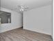 Airy bedroom with wood-look floors, neutral paint, a ceiling fan and a large window for natural light at 7563 Sw 78Th Ter, Ocala, FL 34481