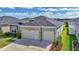 View of the home showing the two-car garage and the well manicured lawn at 7563 Sw 78Th Ter, Ocala, FL 34481