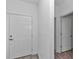 Bright foyer with white walls and wood-look tile flooring, showing the front door and entrance to other rooms at 7563 Sw 78Th Ter, Ocala, FL 34481