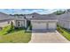 Inviting two-story home with a two-car garage, manicured lawn, and stone accents, creating curb appeal at 7563 Sw 78Th Ter, Ocala, FL 34481