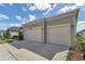 A two-car garage with white doors complementing the home's exterior, set against a blue sky backdrop at 7563 Sw 78Th Ter, Ocala, FL 34481