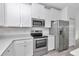 Clean kitchen with stainless steel appliances, white cabinets, and modern countertops at 7563 Sw 78Th Ter, Ocala, FL 34481