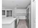 Sleek kitchen featuring white cabinets, stainless steel appliances and a large island with wood-look tile flooring at 7563 Sw 78Th Ter, Ocala, FL 34481