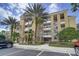 Exterior view of a well-maintained building, complemented by palm trees, tidy landscaping, and convenient parking spaces at 7651 Whisper Way # 104, Reunion, FL 34747