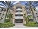 Elegant building exterior with multiple balconies and palm trees, showcasing the architectural design and tropical setting at 7651 Whisper Way # 104, Reunion, FL 34747