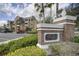 Community entrance sign with manicured shrubs and foliage in front of complex at 7651 Whisper Way # 104, Reunion, FL 34747