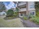 Multi-story building featuring covered patios, surrounded by lush greenery and landscaping at 7651 Whisper Way # 104, Reunion, FL 34747