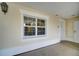 Exterior view showing a large window with white trim and stucco wall under a covered entry at 7651 Whisper Way # 104, Reunion, FL 34747
