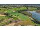 Scenic aerial view of a lush golf course with water features and mature trees at 7651 Whisper Way # 104, Reunion, FL 34747