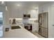 Bright kitchen with stainless steel appliances, white cabinets, and quartz countertops at 7651 Whisper Way # 104, Reunion, FL 34747