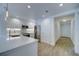 Modern kitchen featuring white cabinets, stainless steel appliances, and wood-look flooring, all brightly lit at 7651 Whisper Way # 104, Reunion, FL 34747