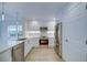 Well-lit kitchen featuring white cabinets, stainless steel appliances, and light-colored wood flooring at 7651 Whisper Way # 104, Reunion, FL 34747