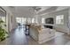 Open floor plan showing a bright living room with sliding glass doors and comfortable seating with a kitchen in back at 7651 Whisper Way # 104, Reunion, FL 34747