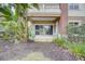 Spacious covered patio with sliding glass doors, nestled amongst lush tropical plants and well-maintained landscaping at 7651 Whisper Way # 104, Reunion, FL 34747