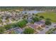 Aerial view of neighborhood homes surrounding a serene lake, bordered by lush green spaces and mature trees at 7718 Cafaro Dr, Orlando, FL 32818