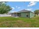 Home's lush backyard featuring a well-maintained lawn, cozy patio, and a white fence at 7718 Cafaro Dr, Orlando, FL 32818