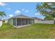 Home's spacious backyard featuring a well-maintained lawn and a cozy screened-in patio at 7718 Cafaro Dr, Orlando, FL 32818
