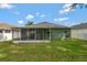 Home's backyard featuring a well-maintained lawn and a cozy screened-in patio at 7718 Cafaro Dr, Orlando, FL 32818