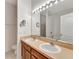Bathroom featuring dual sinks, a large mirror with vanity lighting, and a soaking tub at 7718 Cafaro Dr, Orlando, FL 32818