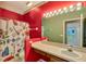 Bathroom with bright red walls, a decorative mirror, and a butterfly-themed shower curtain at 7718 Cafaro Dr, Orlando, FL 32818
