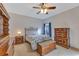 Cozy bedroom with dark wood furniture, ceiling fan, and a bright window for natural light at 7718 Cafaro Dr, Orlando, FL 32818