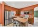 Functional kitchen with an island, stainless steel refrigerator, wood cabinets, and modern appliances at 7718 Cafaro Dr, Orlando, FL 32818