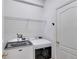 Well-lit laundry room featuring a new front-loading washer and dryer set and storage shelves at 7718 Cafaro Dr, Orlando, FL 32818
