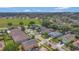 Neighborhood street view with well-maintained homes, mature trees and a green field in the background at 7718 Cafaro Dr, Orlando, FL 32818