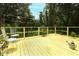 Spacious yellow deck features quaint chairs, plants, and overlooks a serene, tree-filled backyard at 7761 Hillcrest Ter, Orlando, FL 32810