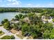 Scenic aerial view of a tranquil lake surrounded by lush greenery and trees under a clear blue sky at 7807 Napoleon St, Orlando, FL 32825