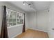 Bedroom with hardwood floors, a closet, and a large window with a nature view at 7807 Napoleon St, Orlando, FL 32825