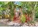 Charming home exterior featuring a bright front door, wood deck, and lush, mature landscaping at 7807 Napoleon St, Orlando, FL 32825