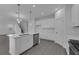 Open-concept kitchen boasts an island, modern appliances, and sleek white cabinets and countertops at 9153 Harris Hawk Dr, Leesburg, FL 34788
