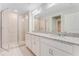 Bathroom features a double sink vanity, granite counters, and glass enclosed shower at 9568 Starling Loop, Leesburg, FL 34788
