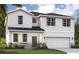 Charming two-story home featuring stone accents, white siding, and an attached two-car garage at 9568 Starling Loop, Leesburg, FL 34788