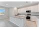 Well-equipped kitchen with granite island, stainless steel appliances, white cabinetry, and tile flooring at 9568 Starling Loop, Leesburg, FL 34788