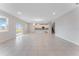 Open-concept living room featuring tile flooring and large windows providing natural light, connected to a modern kitchen at 9568 Starling Loop, Leesburg, FL 34788