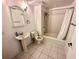 Bathroom features pedestal sink, tiled floors, updated fixtures, tub, and shower combo at 10 N Summerlin Ave # 25, Orlando, FL 32801