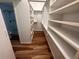 Walk-in closet featuring built-in shelving and hardwood floors, creating a tidy space at 10 N Summerlin Ave # 25, Orlando, FL 32801
