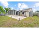 Backyard view with a set of wicker chairs, umbrella, an enclosed patio, and partial lawn at 11005 Cypress Leaf Dr, Orlando, FL 32825
