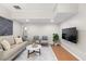 Basement living room area with hardwood-style floors, a modern sofa, and wall-mounted TV at 11005 Cypress Leaf Dr, Orlando, FL 32825