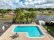 Overhead view of the community pool features lounge chairs, palm trees and a view of the nearby lake at 11005 Cypress Leaf Dr, Orlando, FL 32825