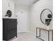 Bright entryway featuring a stylish console table with decor, a round mirror, and a storage cabinet at 11005 Cypress Leaf Dr, Orlando, FL 32825