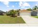 Charming single-story home featuring a well-manicured lawn, beautiful landscaping, and a two-car garage at 11005 Cypress Leaf Dr, Orlando, FL 32825
