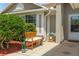 Inviting front porch area with well-maintained landscaping, a cozy bench, and stylish decorations at 11005 Cypress Leaf Dr, Orlando, FL 32825
