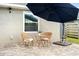 Outdoor patio area with a set of wicker chairs with cushions and a sun umbrella at 11005 Cypress Leaf Dr, Orlando, FL 32825