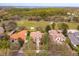 Aerial view of the property, showcasing a house with a red tile roof, lush trees, and a nearby golf course at 11139 Camden Park Dr, Windermere, FL 34786