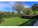 Well-manicured backyard featuring lush lawn, decorative shrubbery, and black metal fencing at 11139 Camden Park Dr, Windermere, FL 34786