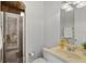 Cozy bathroom featuring a glass enclosed shower and neutral colored stone countertops and backsplash at 11139 Camden Park Dr, Windermere, FL 34786